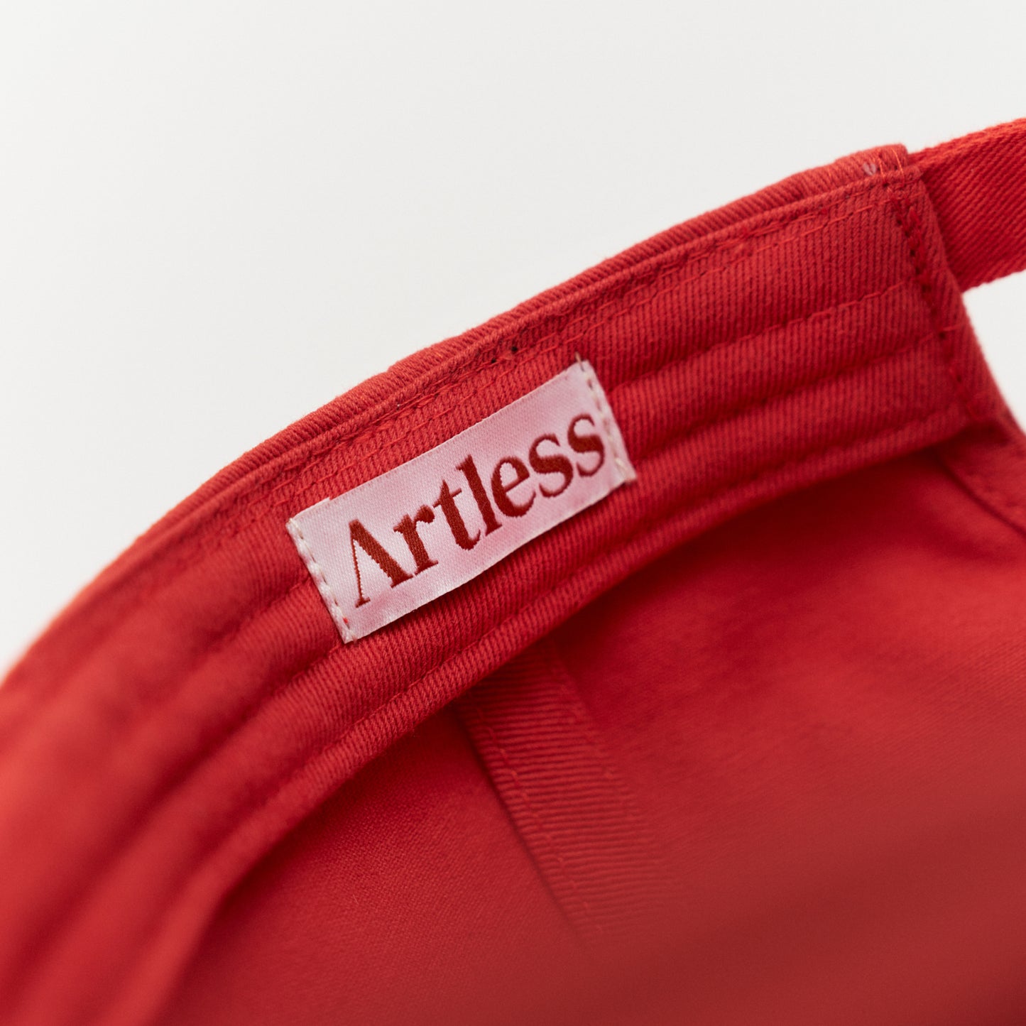 Artless red cap with blue text inside detail lip