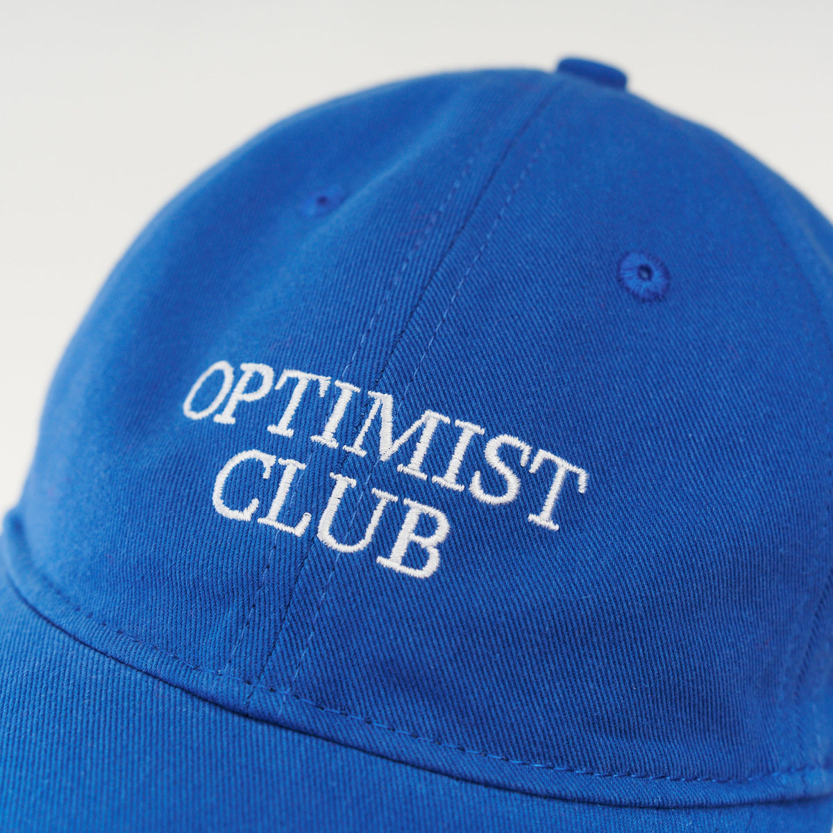 Blue Artless Optimist Club organic dad cap, front view, unstructured 6-panel GOTS organic cotton