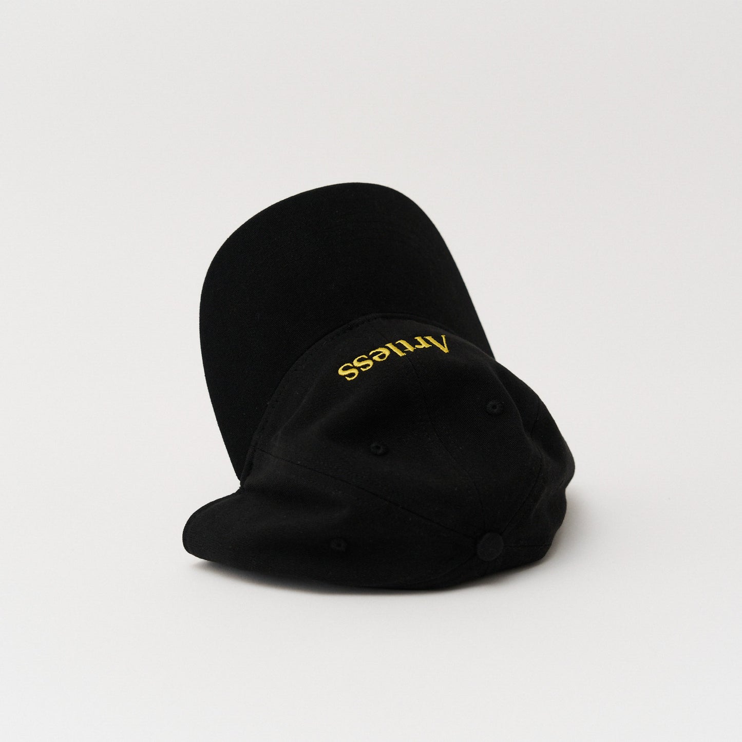 Black unstructured 6-panel dad cap made from GOTS certified organic cotton by Artless tipped over on its side