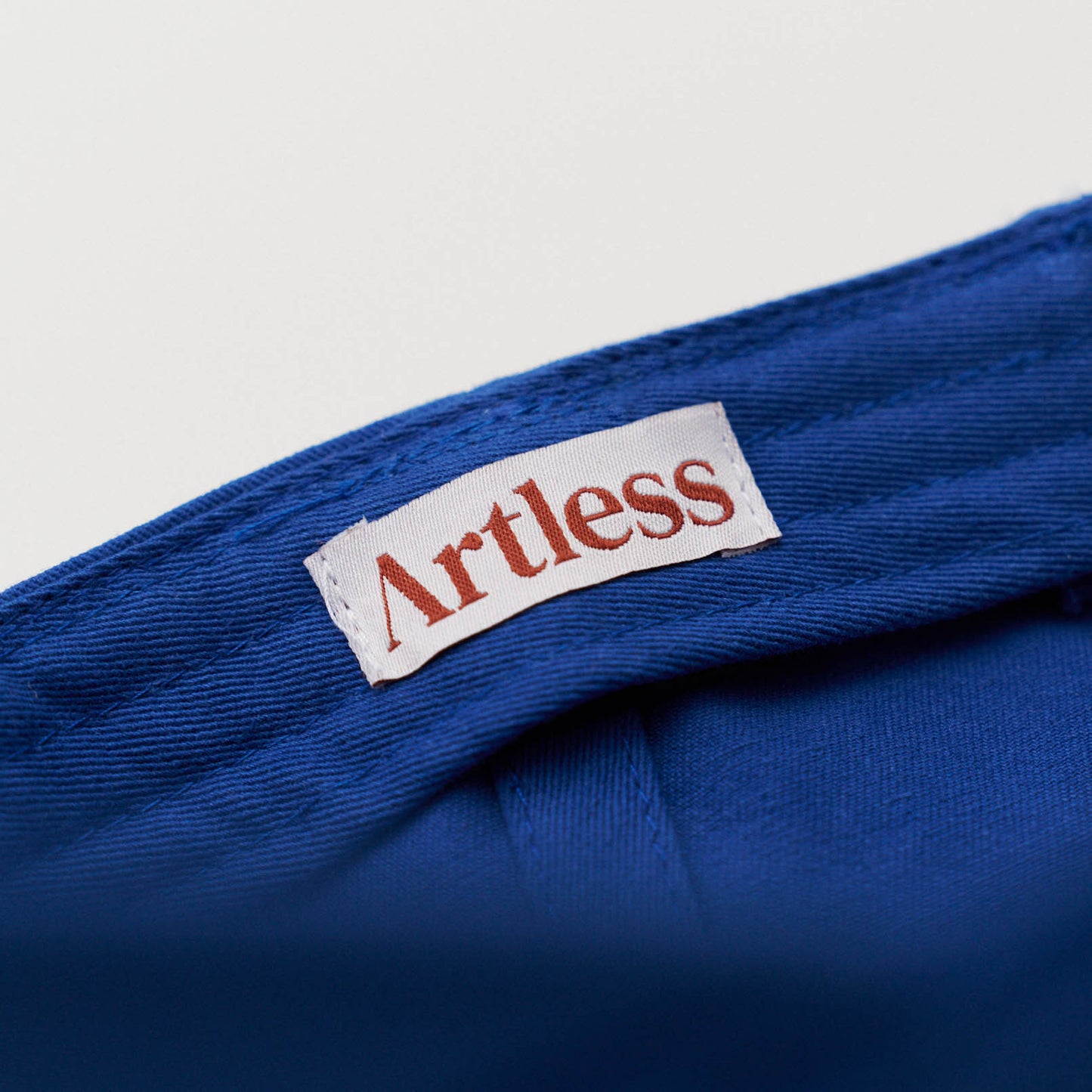 artless label in a blue unstructured 6-panel dad cap made from GOTS certified organic cotton