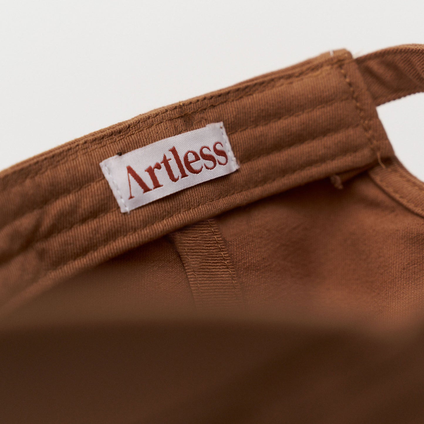 Artless label in a brown unstructured 6-panel dad cap made from GOTS certified organic cotton