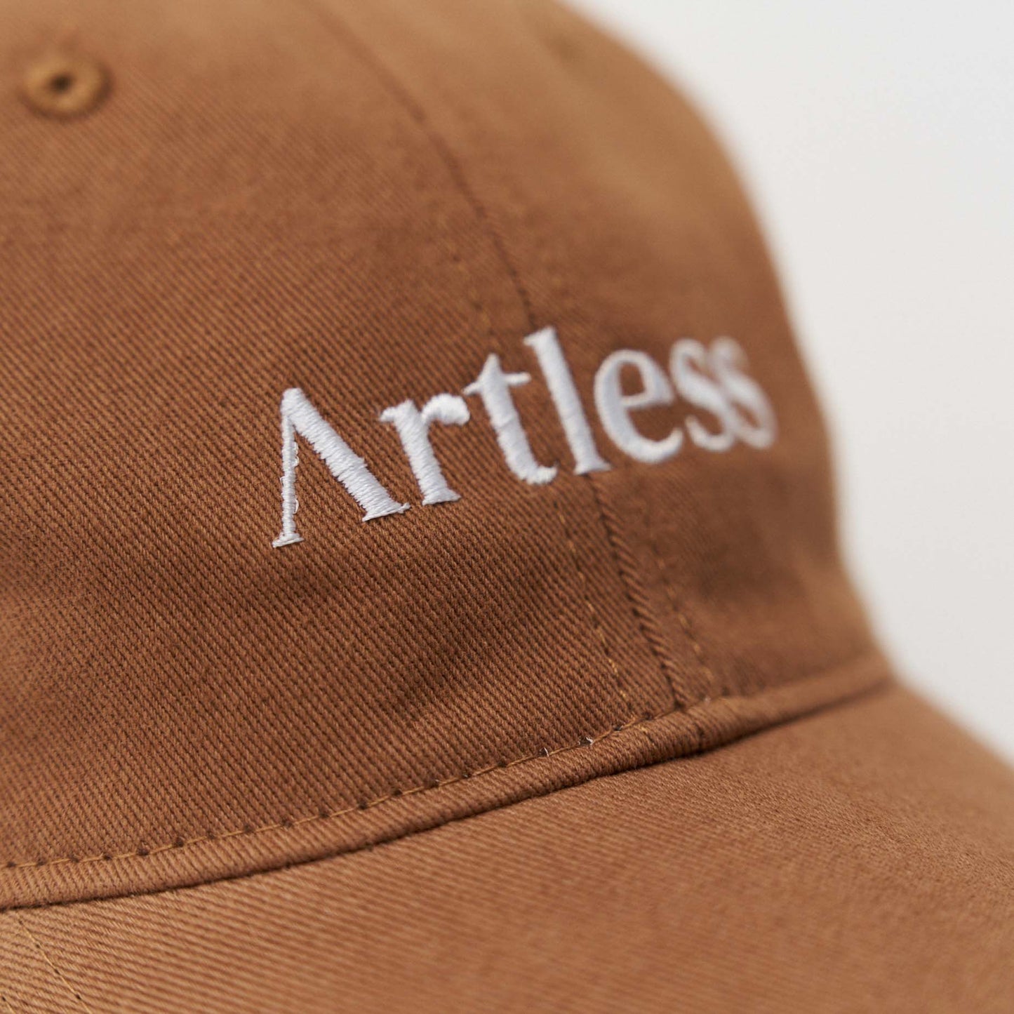 Close up of the embroidery of a brown unstructured 6-panel dad cap made from GOTS certified organic cotton by Artless