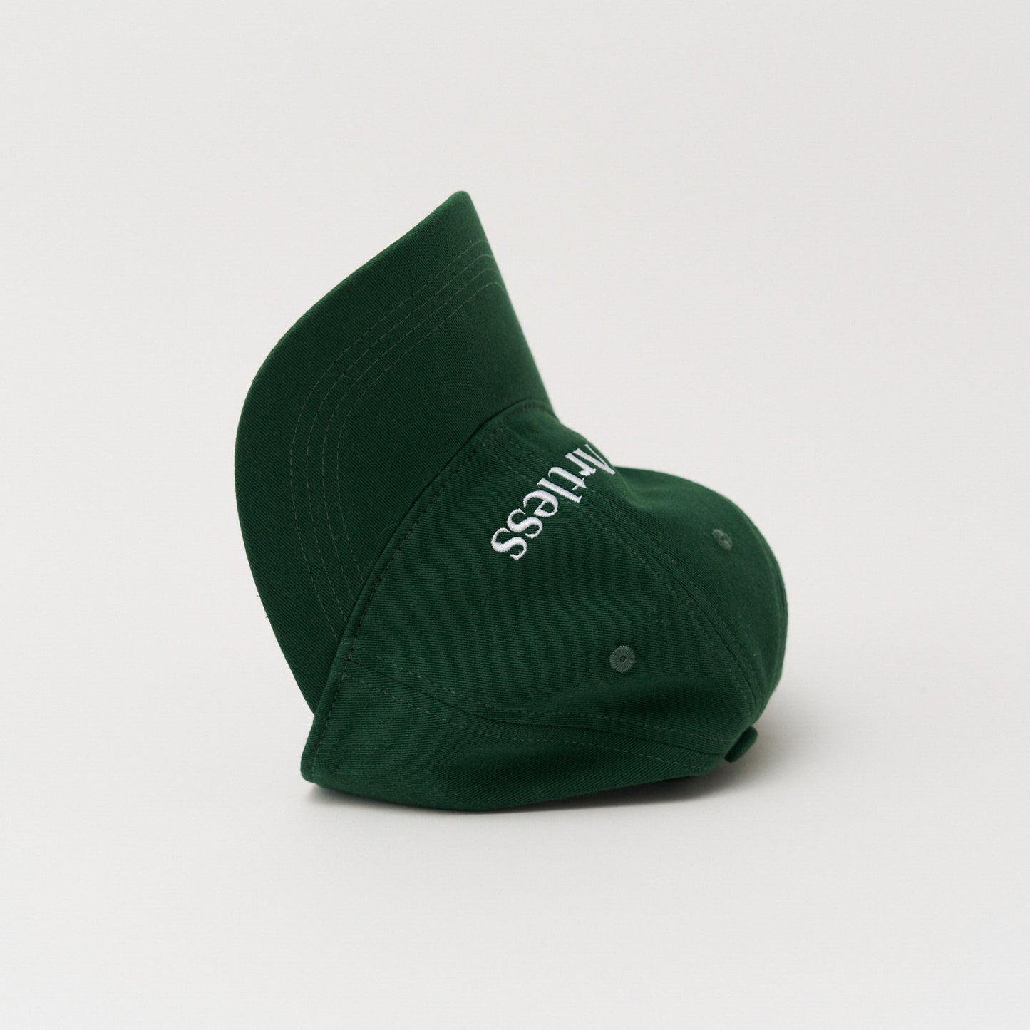 Green unstructured 6-panel dad cap made from GOTS certified organic cotton by Artless tipped on it's side