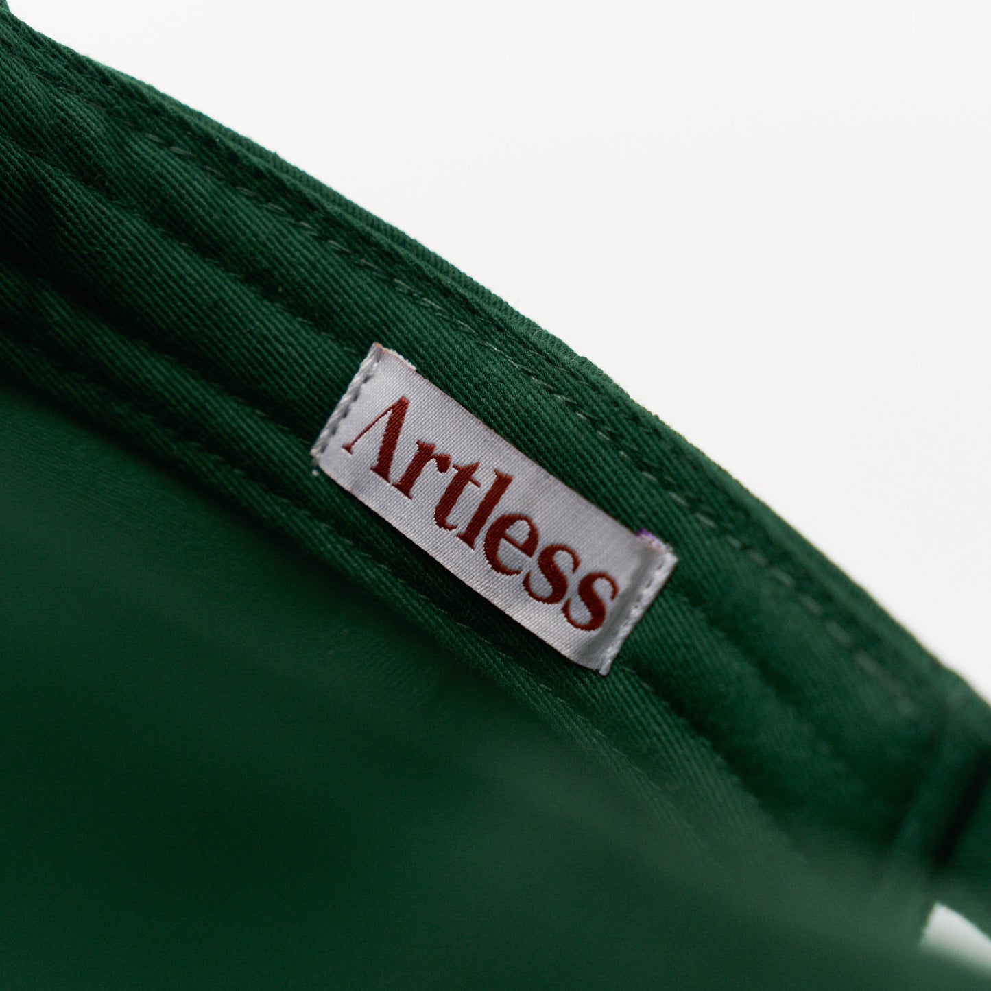 Artless label inside a green unstructured 6-panel dad cap made from GOTS certified organic cotton