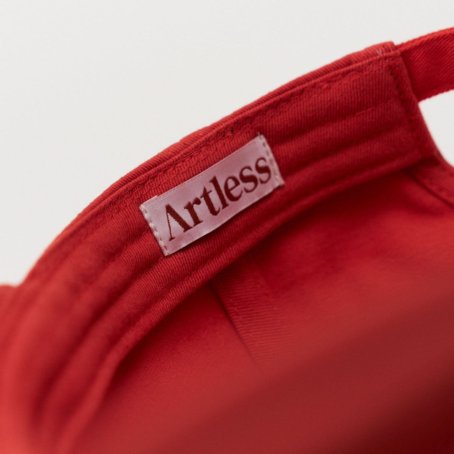 Artless label in a red unstructured 6-panel dad cap made from GOTS certified organic cotton