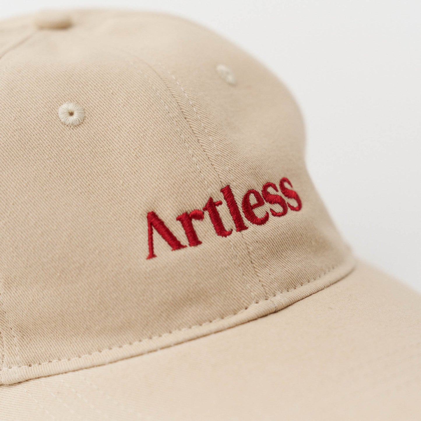 Close up of the embroidery of a sand coloured unstructured 6-panel dad cap made from GOTS certified organic cotton by Artless
