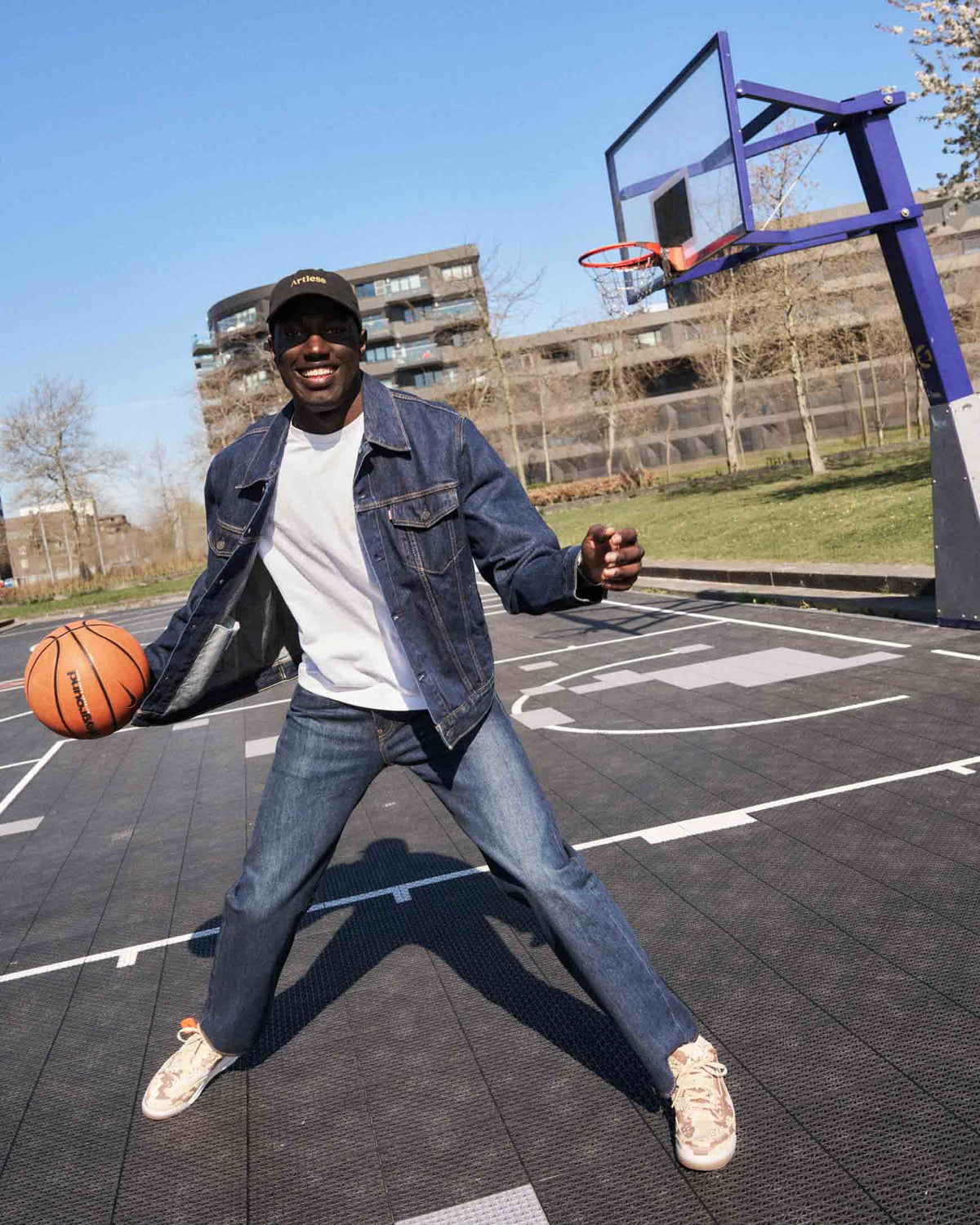 Man playing basketball wearing a black unstructured 6-panel dad cap made from GOTS certified organic cotton by Artless