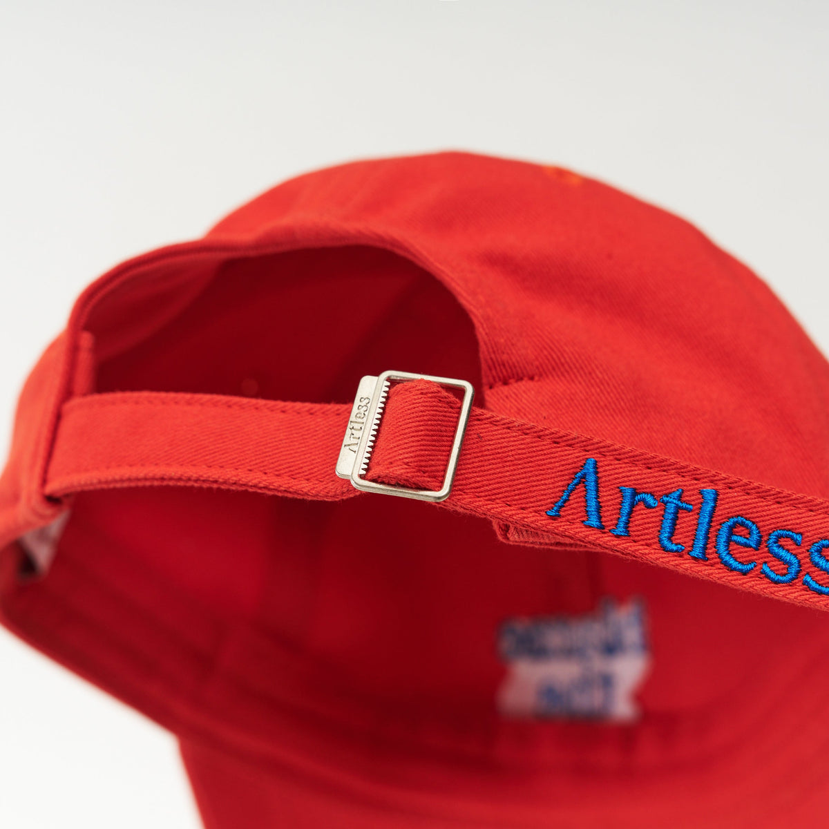 Red Artless blame the moon organic dad cap with blue embroidery, back view with Artless strap, GOTS organic cotton