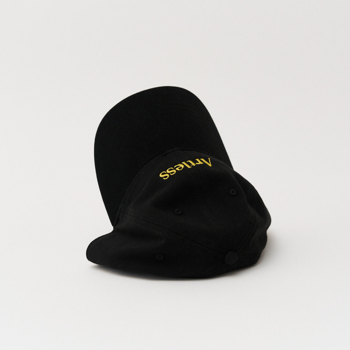 Black unstructured 6-panel dad cap made from GOTS certified organic cotton by Artless tipped over on its side