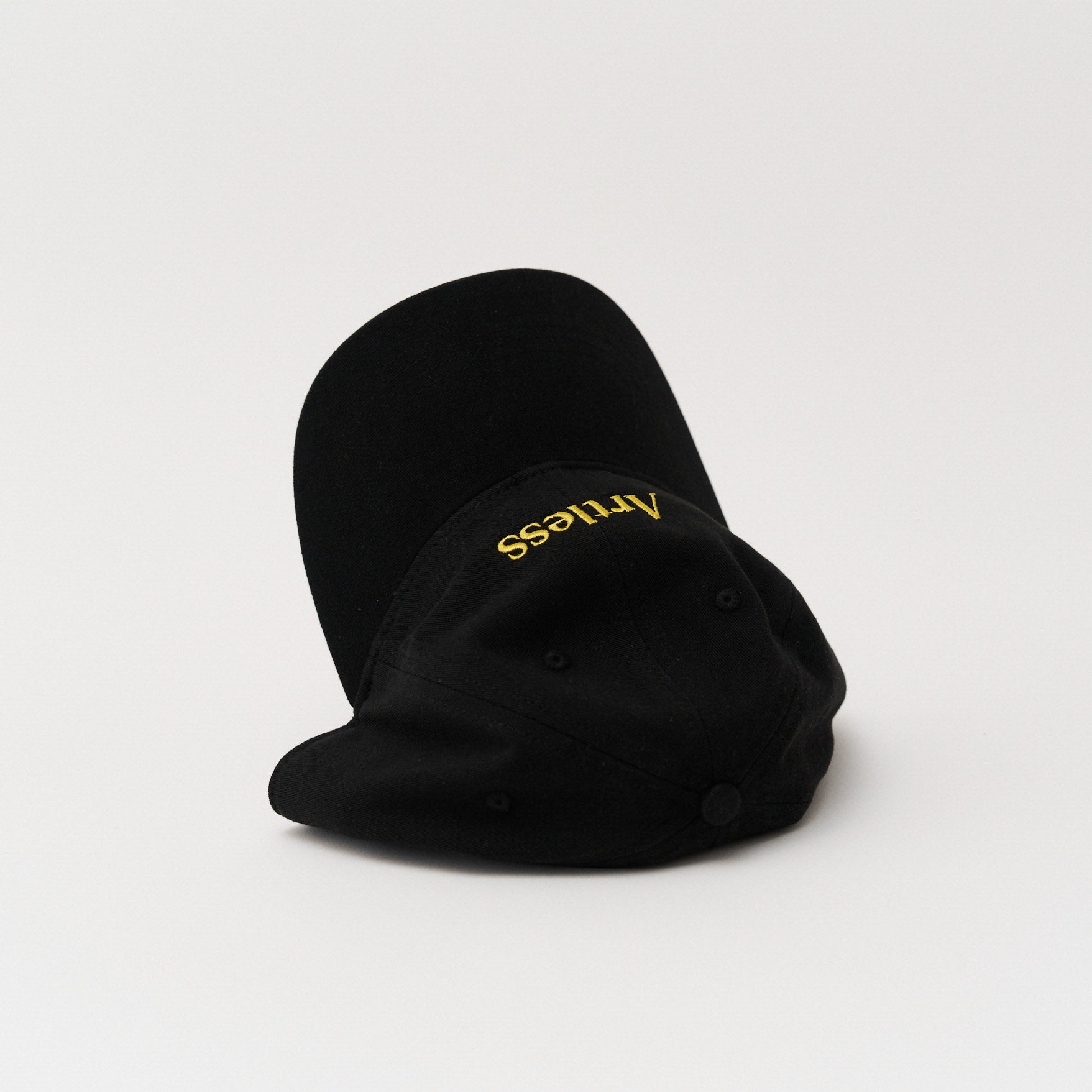 Black unstructured 6-panel dad cap made from GOTS certified organic cotton by Artless tipped over on its side