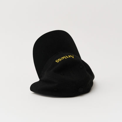 Black unstructured 6-panel dad cap made from GOTS certified organic cotton by Artless tipped over on its side