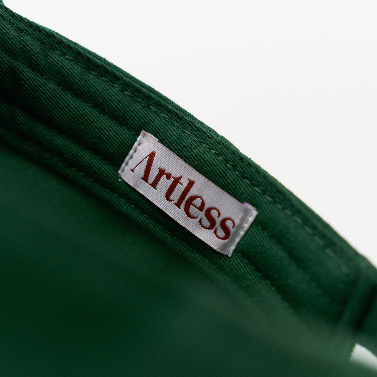Artless label inside a green unstructured 6-panel dad cap made from GOTS certified organic cotton