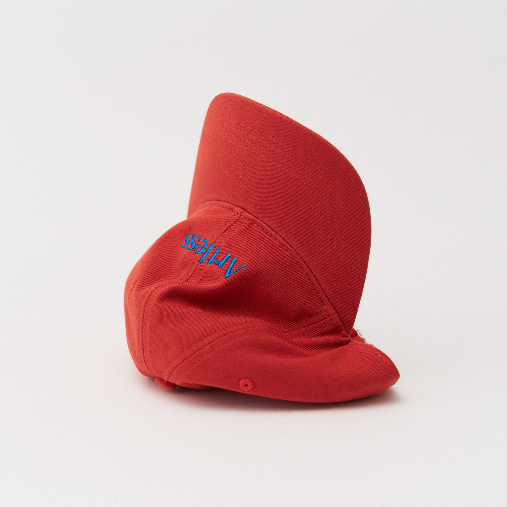 red unstructured 6-panel dad cap made from GOTS certified organic cotton by Artless tipped on its side