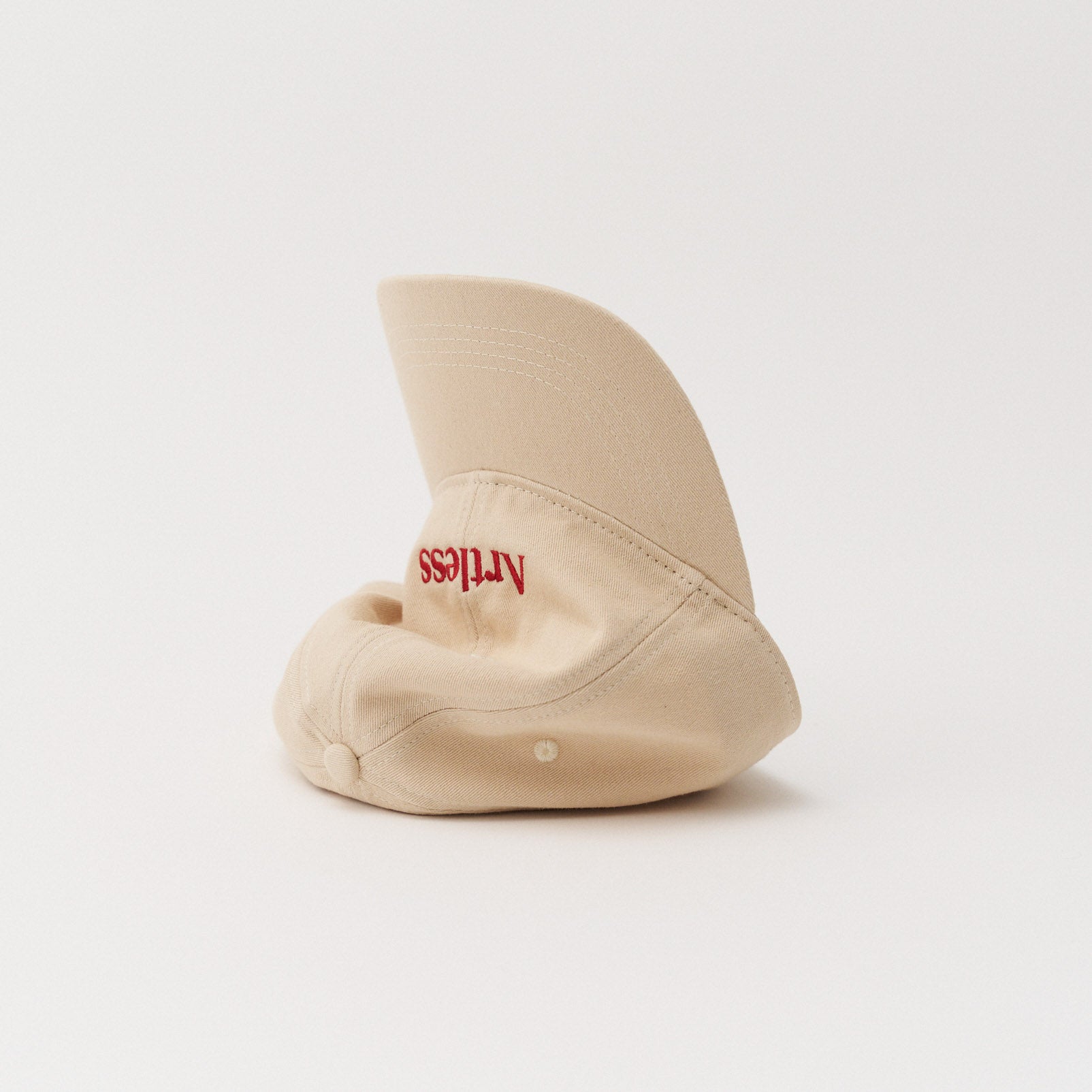 Sand coloured unstructured 6-panel dad cap made from GOTS certified organic cotton by Artless tipped on its side