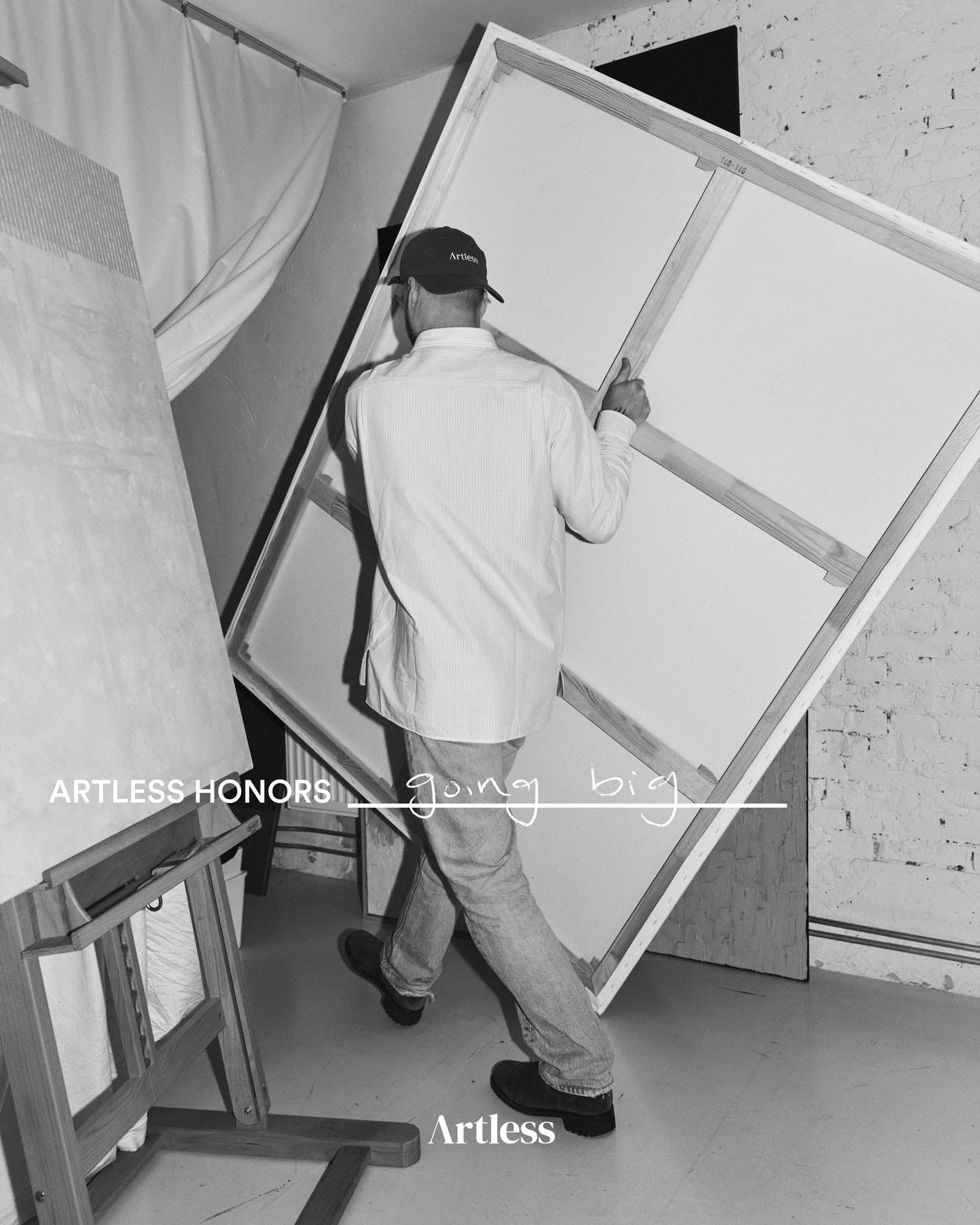 Person installing artwork in a studio wearing a black unstructured 6-panel dad cap made from GOTS certified organic cotton by Artless