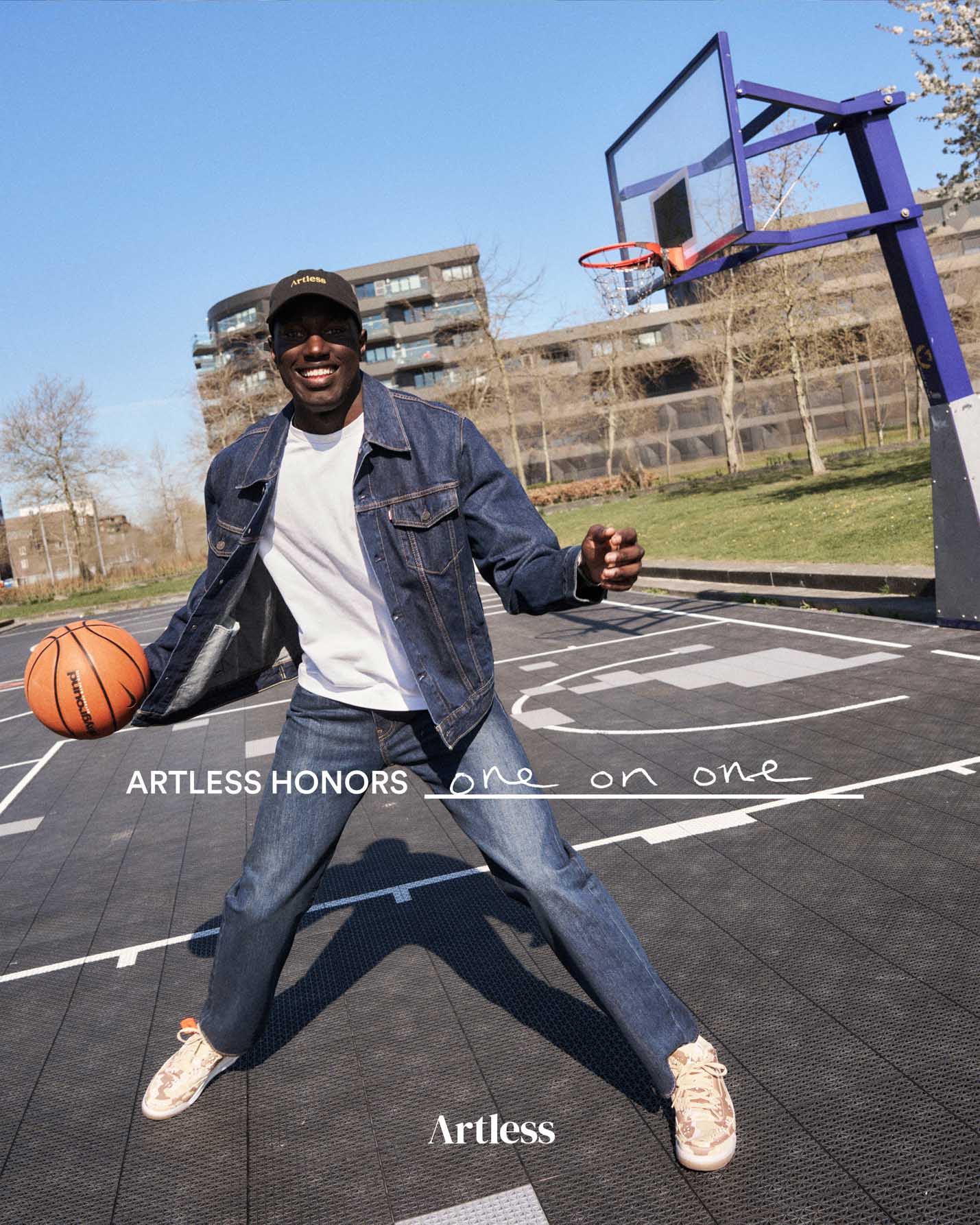 Man posing with a basketball on an outdoor court, wearing a black unstructured 6-panel dad cap made from GOTS certified organic cotton by Artless