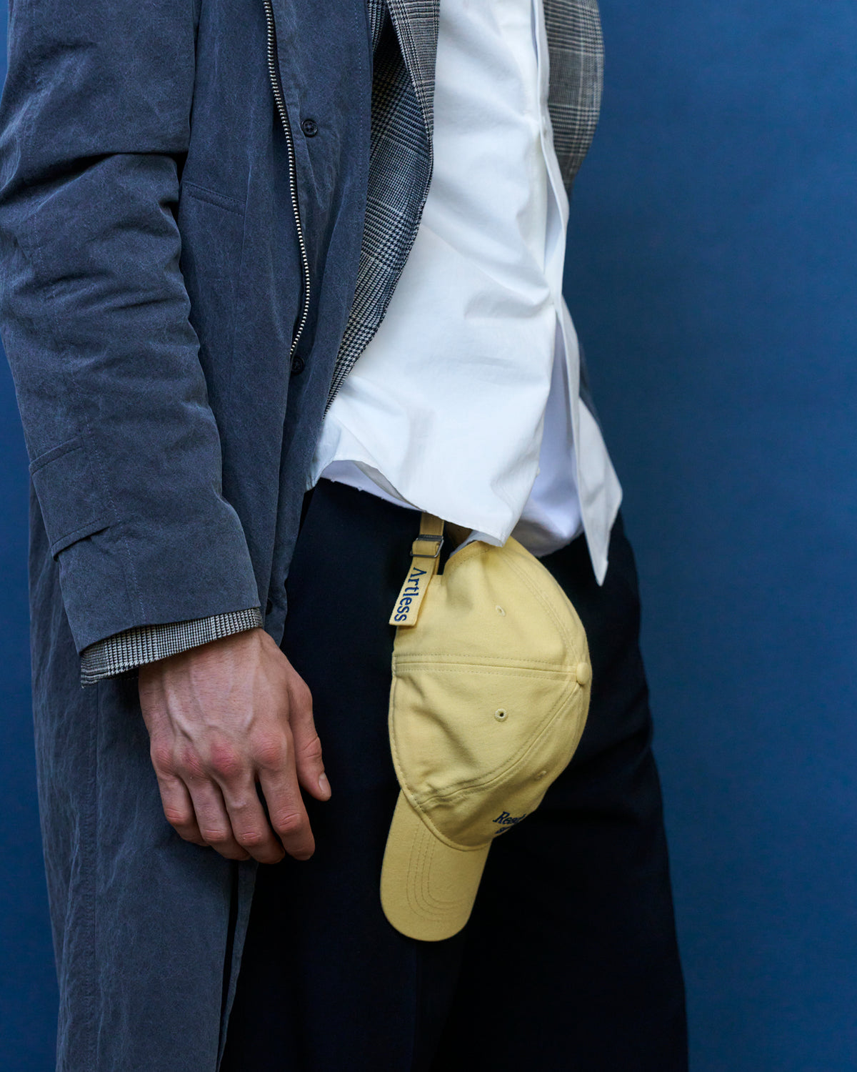 Person holding the butter yellow Artless Ready To Crash And Burn organic cotton dad cap, navy corduroy jacket and white top